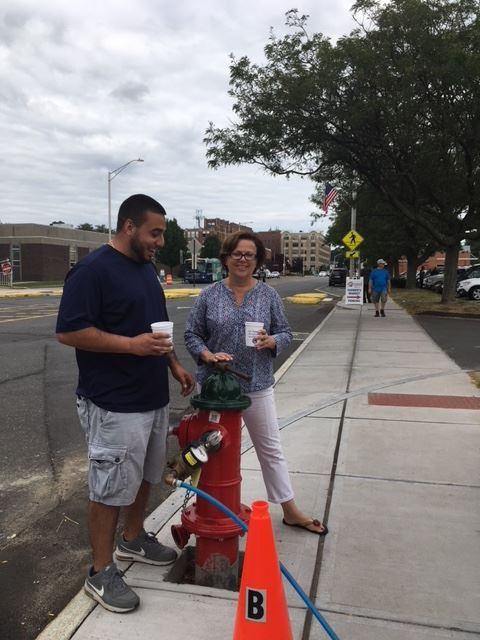 Two people standing at a fire hydrant